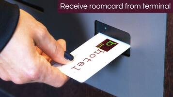 Een hand houdt een kamerkaart vast met een digitaal scherm, wat een moderne, technologische hotelering aangeeft.