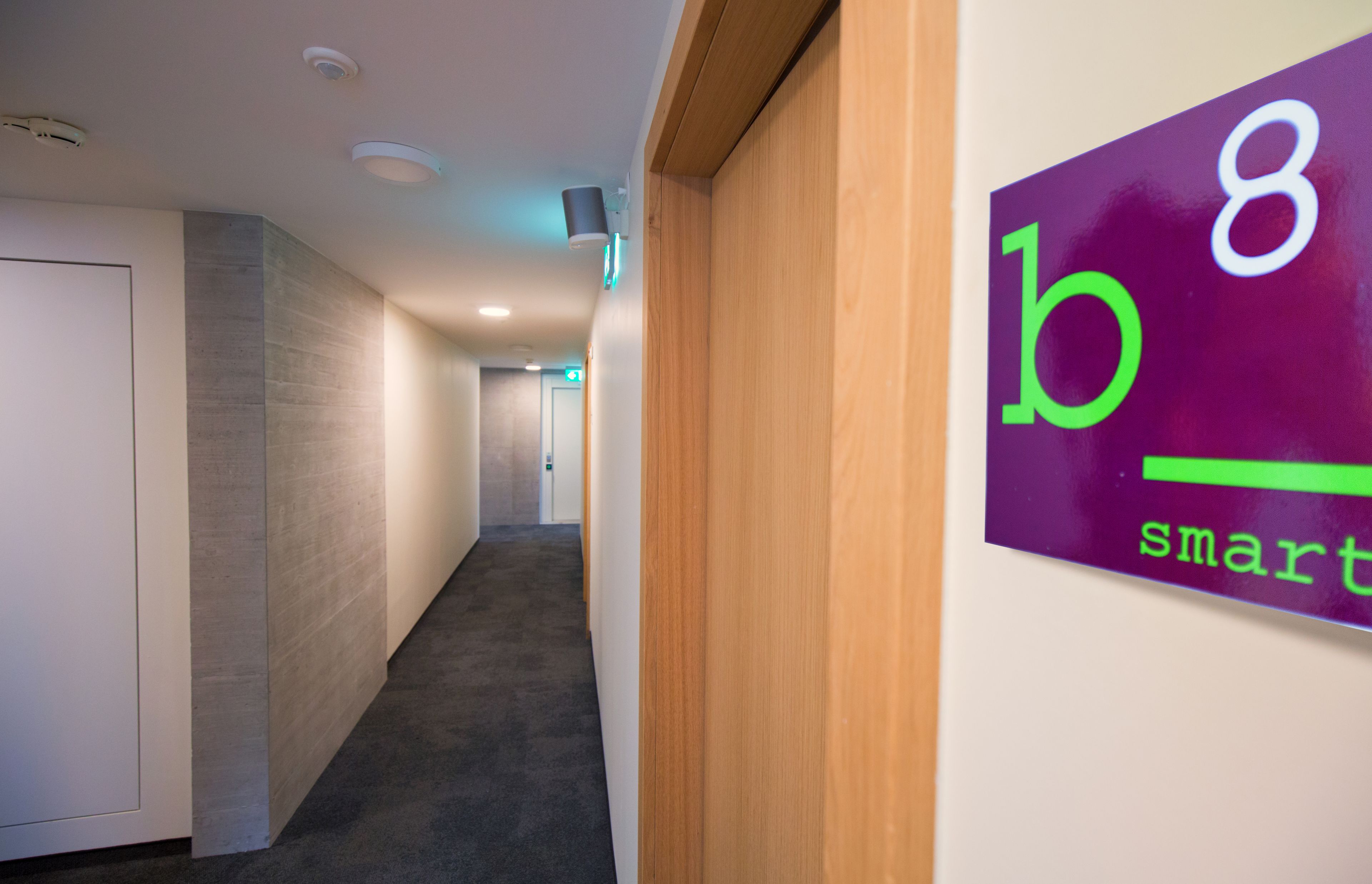 A hallway with a sign reading "b8 smart" on the wall.