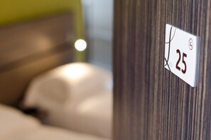 A close-up of a room number sign, '25', on a wooden wall. - Logis Hôtel Le Vert Galant (La Flèche)