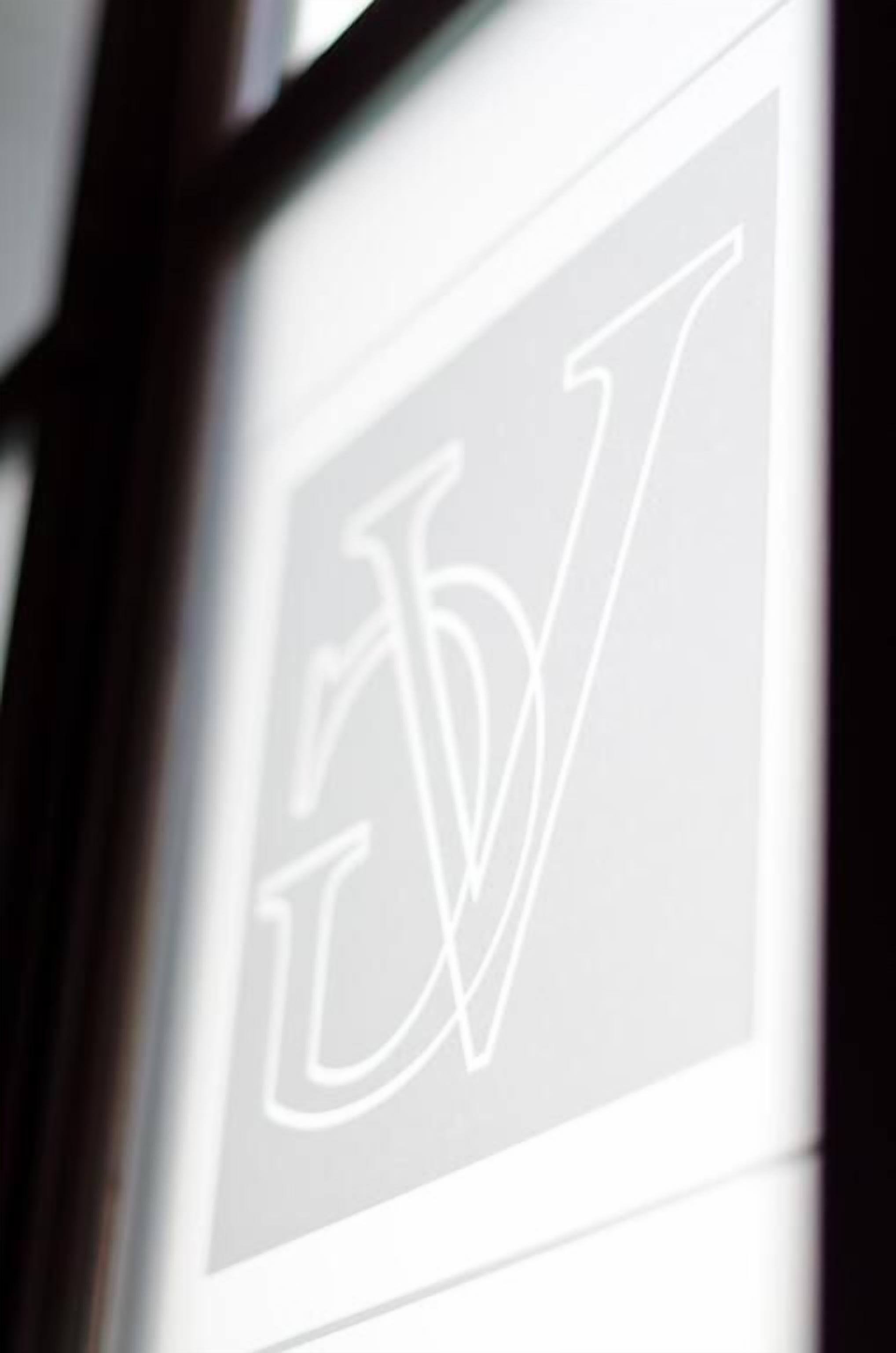 A blurred view of a logo with a stylized 'W' inside a square frame.