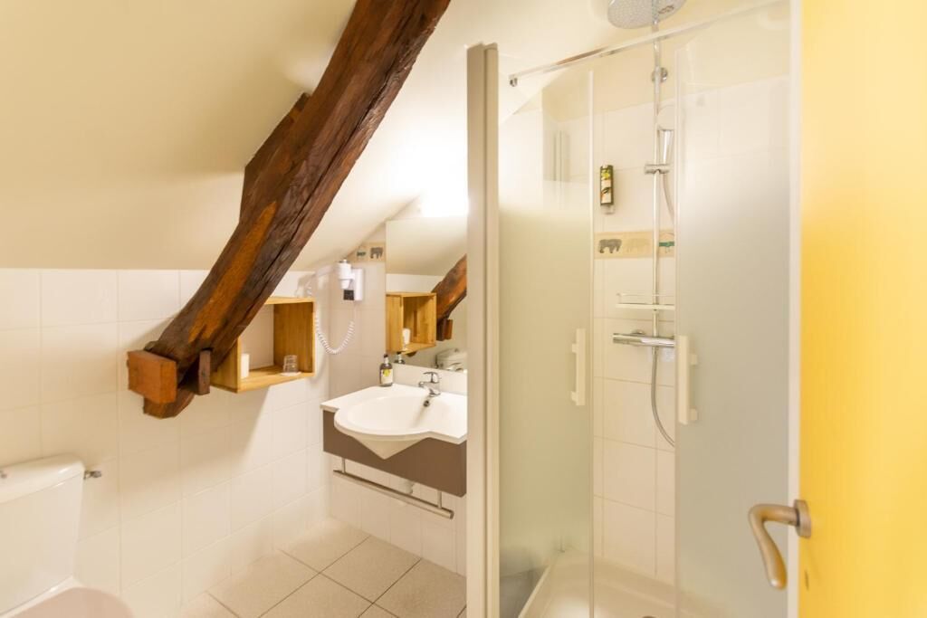 A bathroom with a shower, a toilet, and a sink.