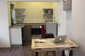 Apartamento, 1 quarto | Cozinha americana privada | Geladeira, micro-ondas, fogão, cooktop