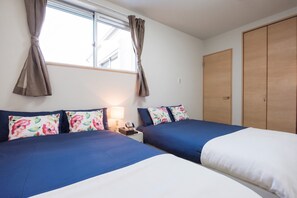 A hotel room with two beds, a nightstand, a lamp, a telephone, and a wardrobe. - Tinker Bell (Osaka)