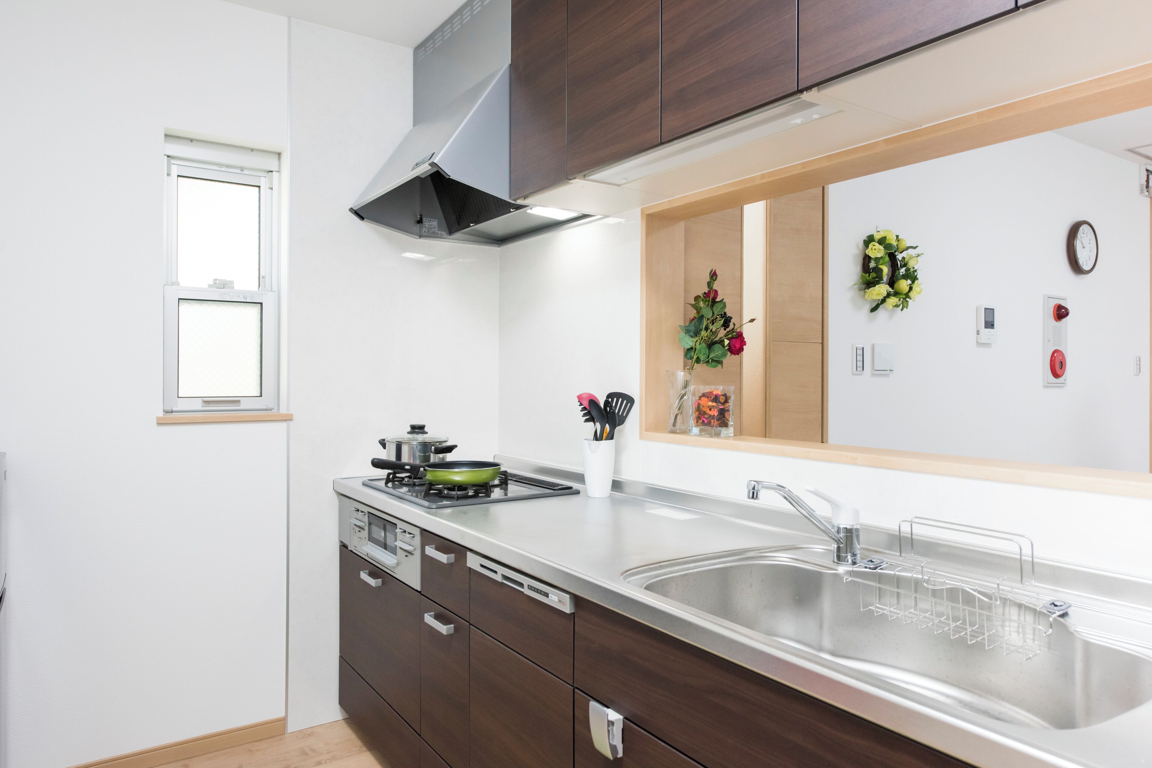 A modern kitchen with a stainless steel sink, a built-in stove, and a range hood.