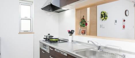 A modern kitchen with a stainless steel sink, a built-in stove, and a range hood.