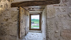 A narrow, rustic room with a small window and a wooden beam above it. - La Grange d'Oustaud (Verac)