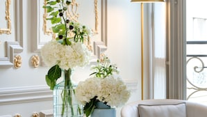 A modern interior with a round table, white sofa, and decorative vases with flowers. - Hôtel Bowmann, a Small Luxury Hotel of the World (Paris)