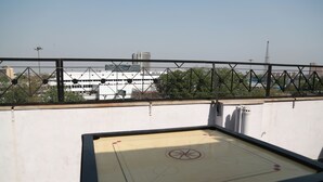 A table tennis table on a rooftop with a view of buildings and a clear sky. - Hotel Geetasaar (New Delhi)