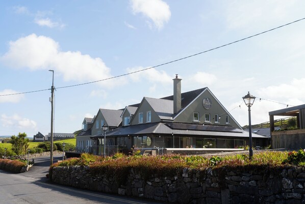 A large, two-story building with a prominent chimney and a covered outdoor seating area.