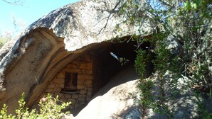 Une structure ressemblant à une grotte, avec une petite fenêtre et des murs en pierre.
