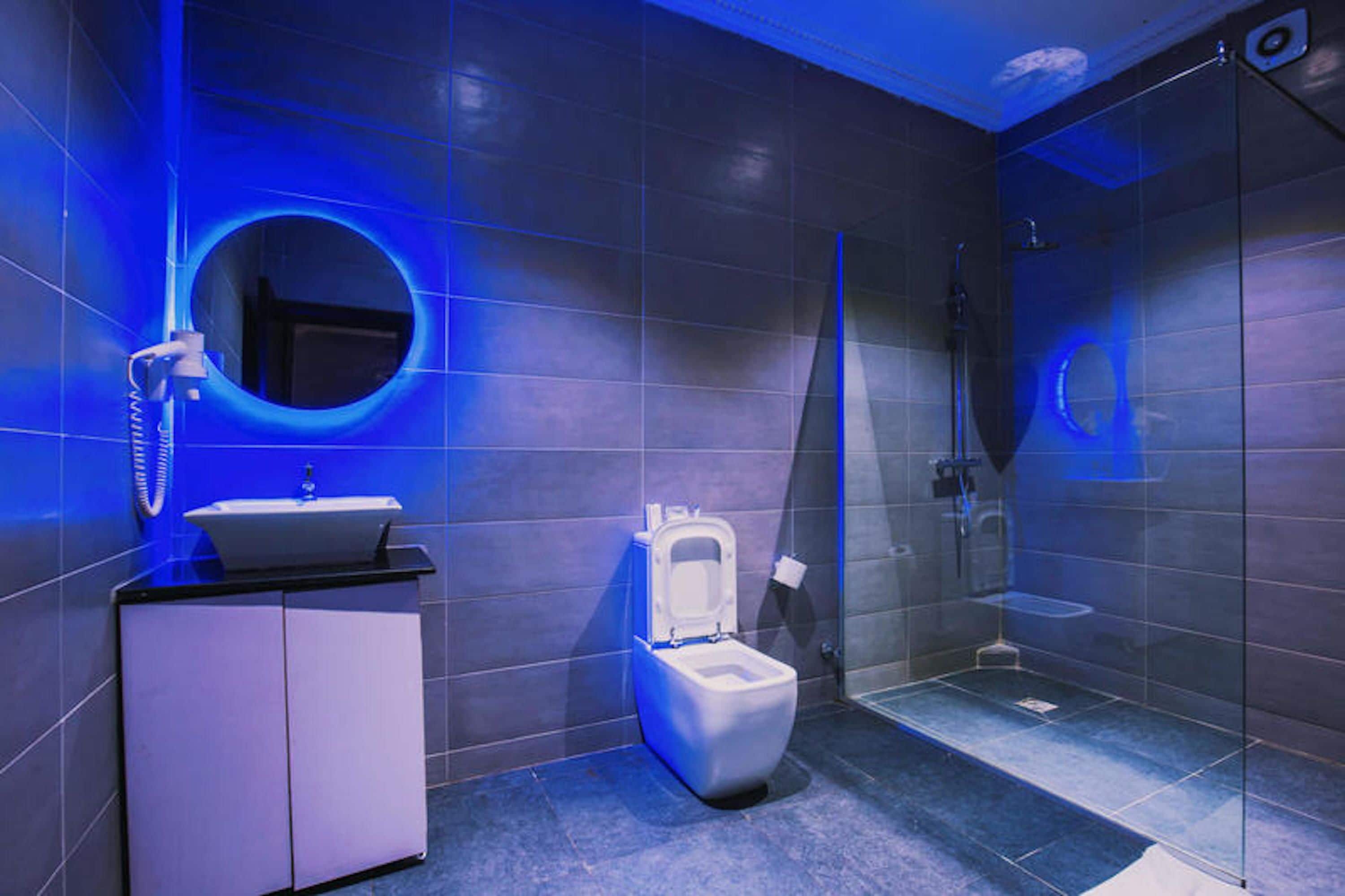 Un baño moderno con inodoro, lavamanos y zona de ducha.