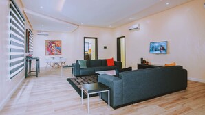 Una sala moderna con un sofá, una mesa de centro y una zona de comedor con sillas.