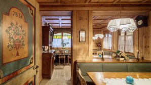 A wooden interior with a dining area, a kitchen, and a hallway.