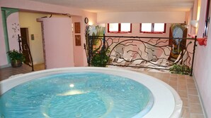 An indoor swimming pool with a tiled floor and a metal railing.