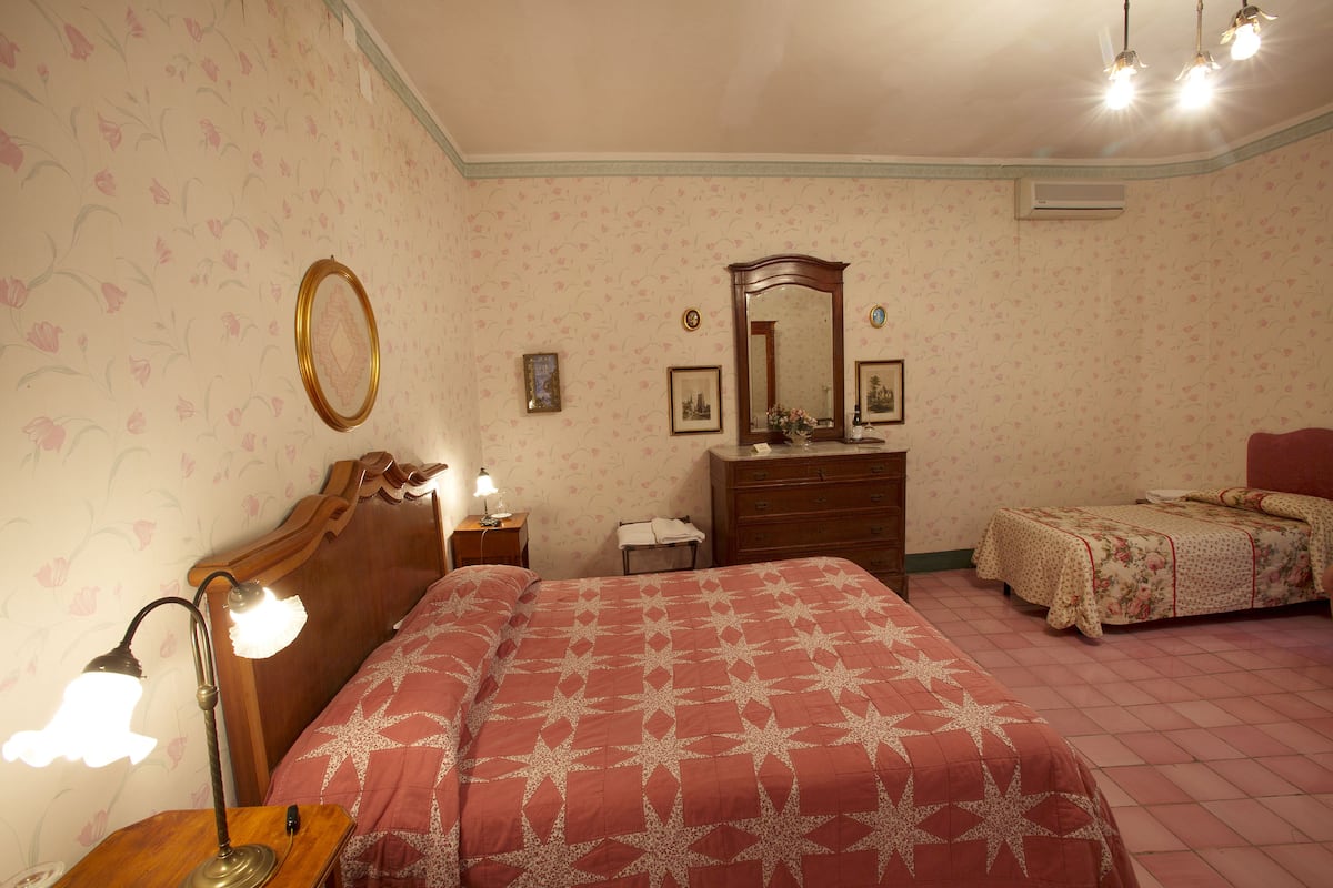 Une chambre à coucher avec un grand lit, une commode, une table de chevet et une petite table avec une lampe.