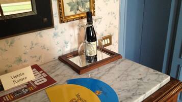 Un comptoir en marbre avec une bouteille de vin, un cadre photo et un présentoir à menus.