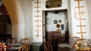 A dining area with wooden chairs, tables set for two, and a rustic decor including a star-shaped light fixture and a lantern. - Agriturismo Mustilli (Sant'Agata de'Goti)