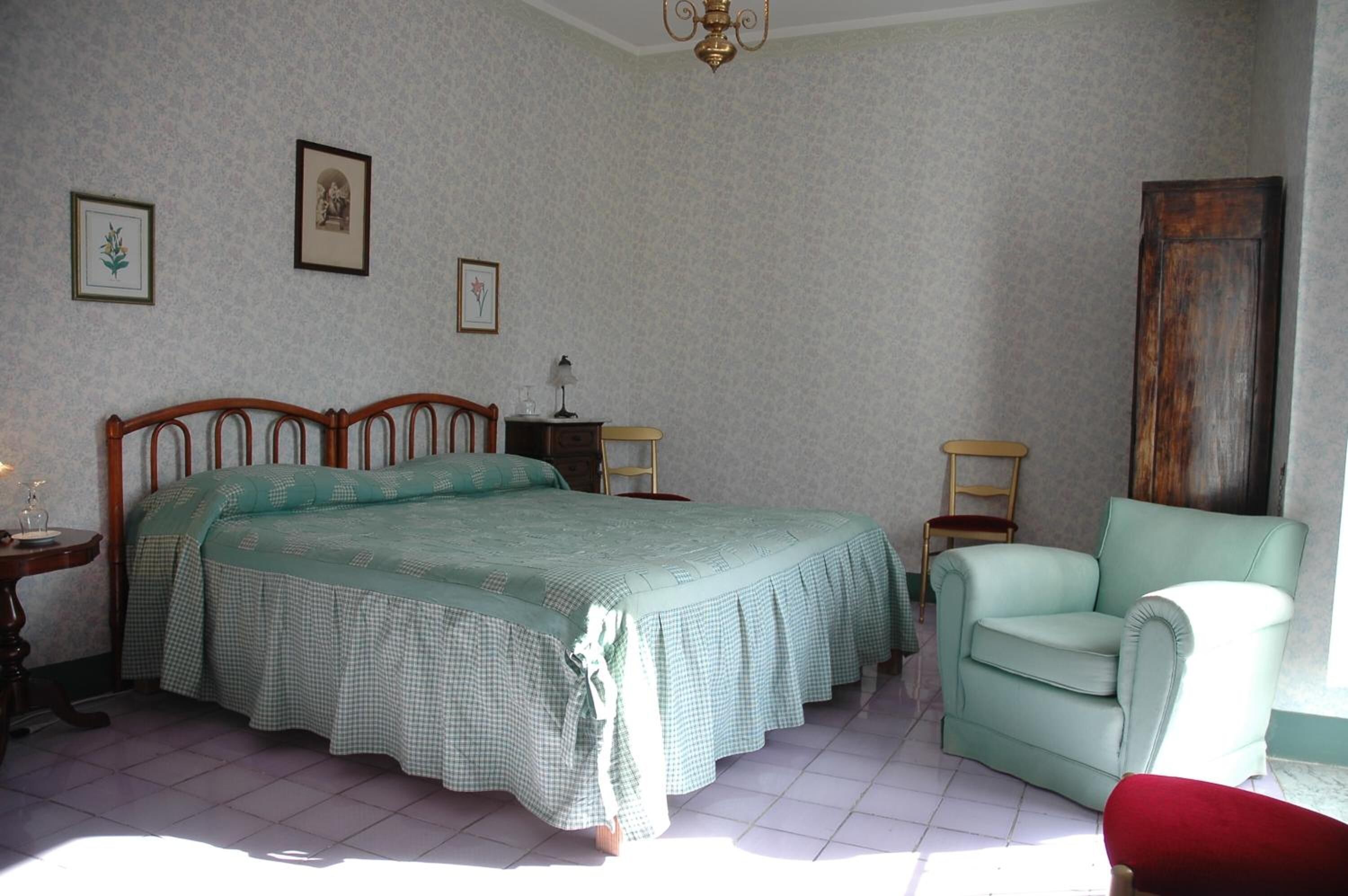 Una camera da letto con un letto grande, una sedia, un comodino e un'armadio in legno.