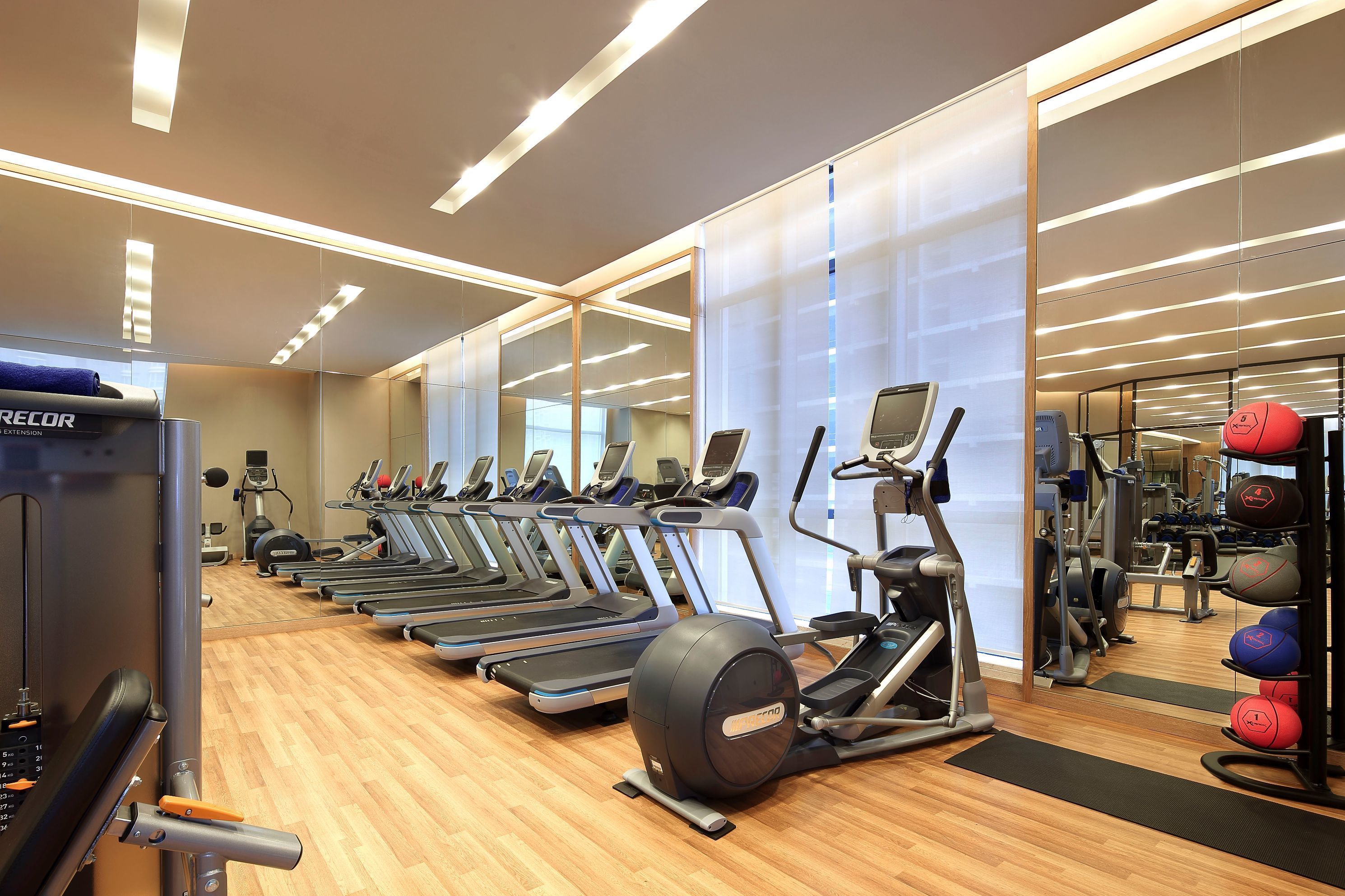 A gym with treadmills, elliptical machines, and weightlifting equipment.