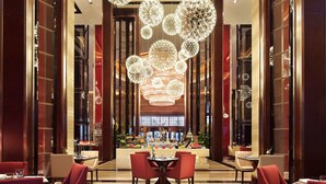 A spacious lobby with a central reception desk, multiple seating areas, and decorative spherical light fixtures. - Wanda Realm Anyang (Anyang)