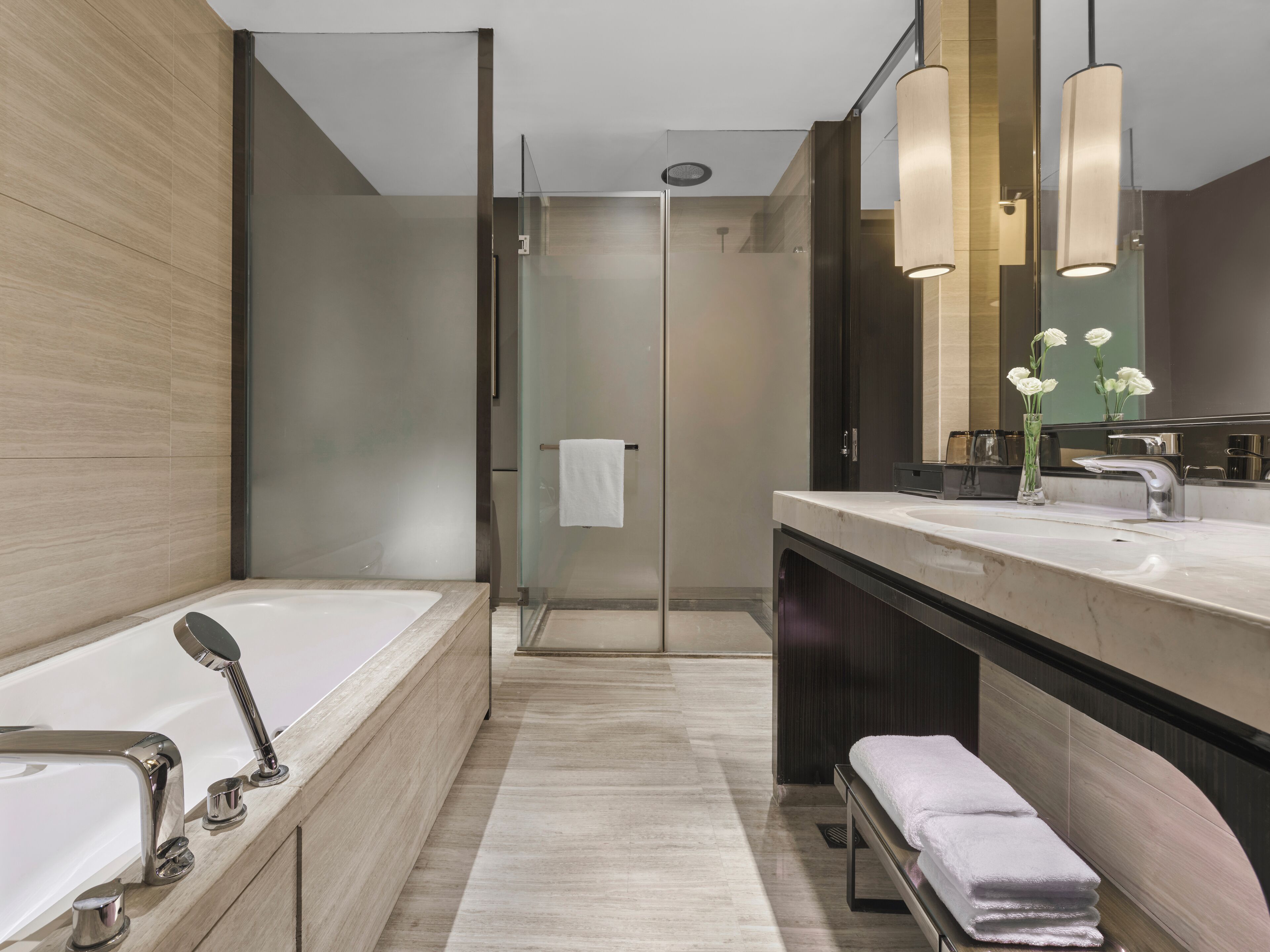 Un baño moderno con bañera, ducha y tocador con espejo.