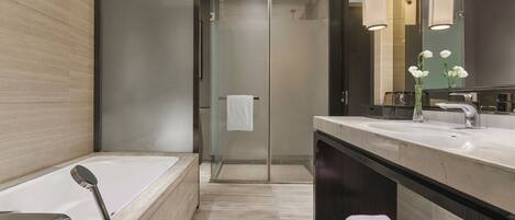 Un baño moderno con bañera, ducha y tocador con espejo.