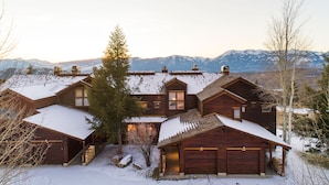 A large wooden house with multiple garages and a snow-covered landscape. - Outpost: Spirit Dance 3110 - Summer Pool Access! (Jackson)