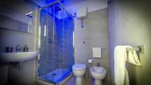 A modern bathroom with a glass-enclosed shower, a sink, a toilet, and a bidet. - Mr. Charlie Brown (Rome)