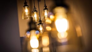 A cluster of hanging light bulbs with visible filament bulbs. - Mr. Charlie Brown (Rome)