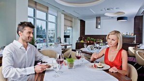 Un comedor moderno con una mesa para dos, ventanas amplias y vistas al exterior.