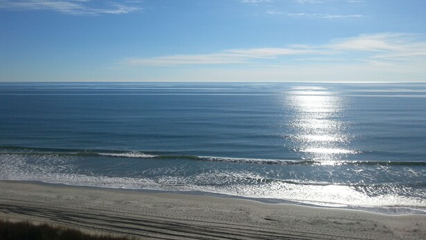 A beach with a clear sky and calm sea.