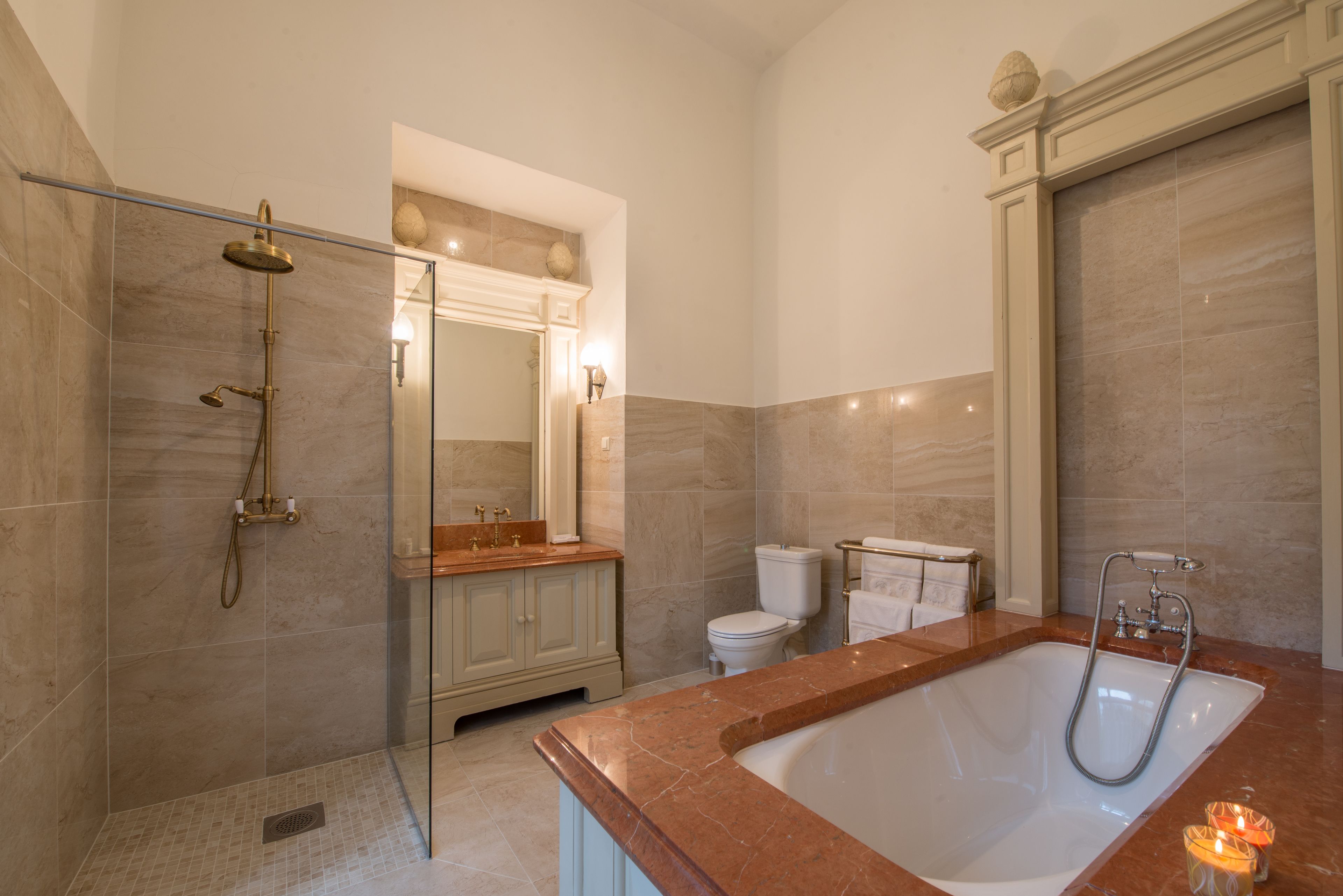 A modern bathroom with a glass-enclosed shower, a freestanding bathtub, and a vanity with a mirror.