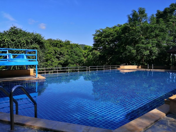 A clear blue pool with a blue diving platform and metal railings. - Cabbages & Condoms Khaoyai Resort (Pak Chong)