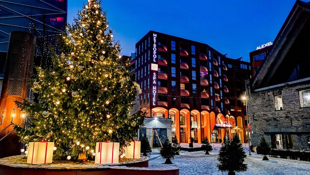 A Christmas tree with lights and ornaments in front of a building with a spa hotel sign. - Metropol Spa Hotel (Tallinn)