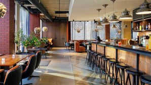 A modern bar area with high stools, a long counter, and pendant lighting. - Metropol Spa Hotel (Tallinn)