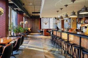A modern bar area with high stools, a long counter, and pendant lighting. - Metropol Spa Hotel (Tallinn)