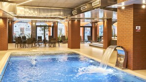 A pool area with a water feature, brick walls, and outdoor seating. - Metropol Spa Hotel (Tallinn)