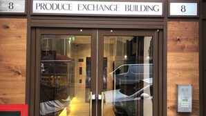 L’entrée du bâtiment de la Bourse des produits, avec une porte en verre et un clavier de sécurité.