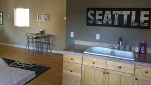 Una cocina con armarios de madera, encimera de granito y un cuadro grande colgado en la pared de Seattle.
