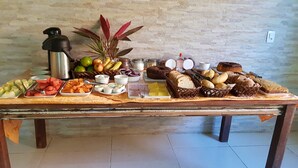 A buffet table with various food items and a water dispenser. - Pousada Destino Buzios (Búzios)