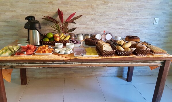 A buffet table with various food items and a water dispenser.