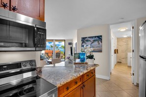 Eine moderne Küche mit Edelstahlgeräten, einer Marmorarbeitsplatte und Holzschränken.