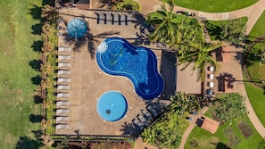 An aerial view of a resort with two swimming pools, palm trees, and lounge chairs. - Penthouse Oceanview Vistas (Kihei, Maui)