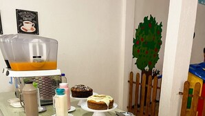 Une table de buffet proposant divers plats, notamment des fruits coupés, des pâtisseries et un assortiment de viandes.