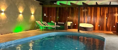 Een buitenzwembad, ligstoelen bij het zwembad