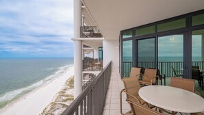 A balcony with a view of the beach and ocean, furnished with a table and chairs. - The Oasis at Orange Beach, formerly known as Phoenix West II, Unit 2609 (Orange Beach)