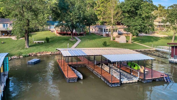 A floating dock with a covered seating area and a small boat.