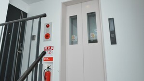A staircase with a handrail, a fire alarm, and a fire extinguisher. - The Wonder At Stay-Tengachaya- (Osaka)
