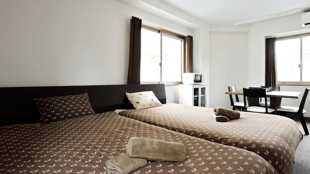 A hotel room with two beds, a desk, and a chair. - The Wonder At Stay-Tengachaya- (Osaka)