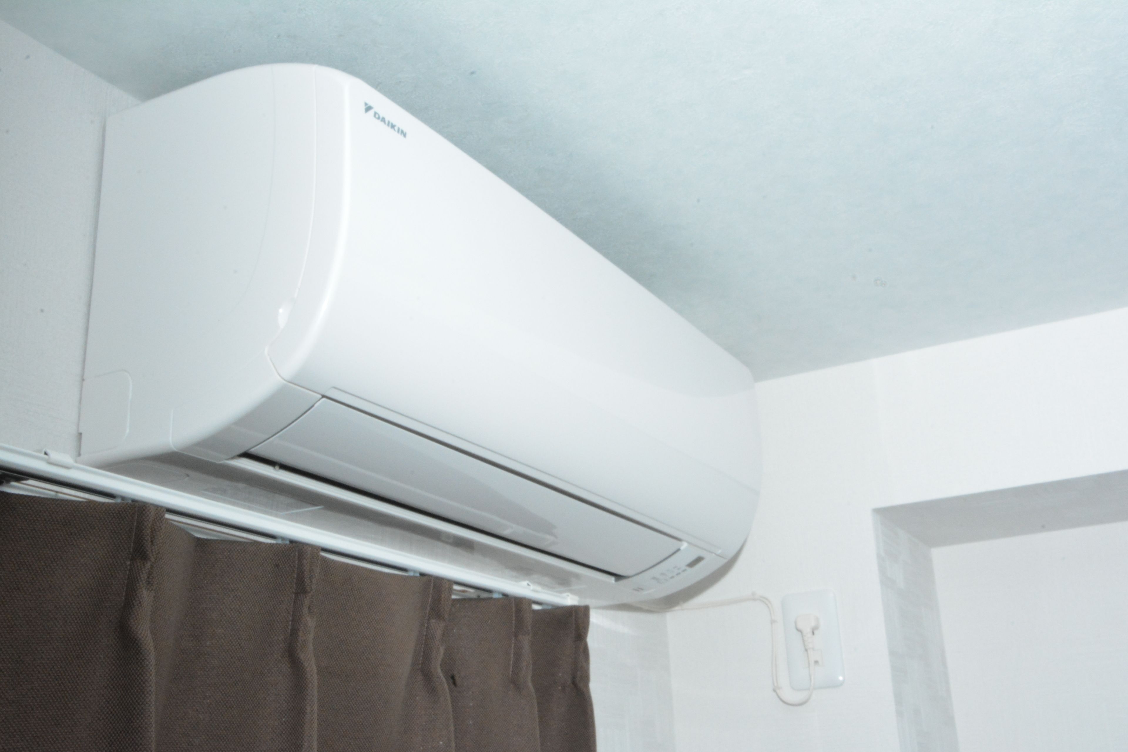 Un equipo de aire acondicionado blanco montado en la pared de un baño.